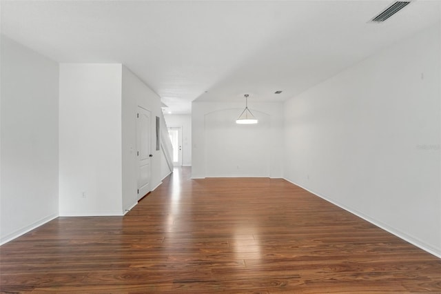 empty room with visible vents, baseboards, and wood finished floors
