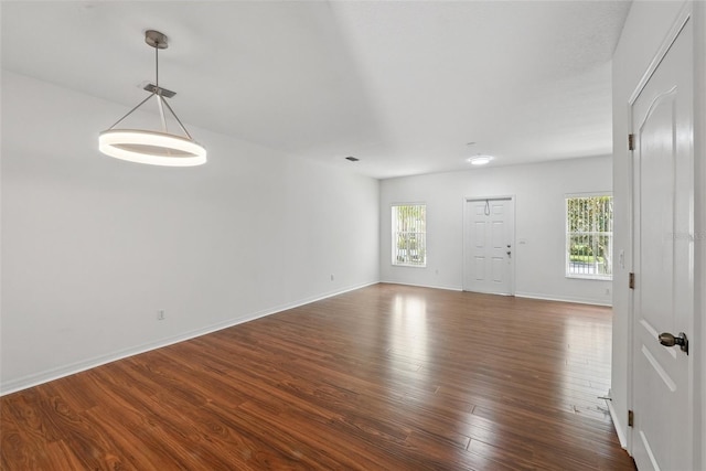 empty room with dark wood-style flooring and baseboards