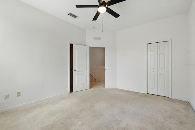 unfurnished bedroom featuring a ceiling fan, baseboards, visible vents, and light carpet