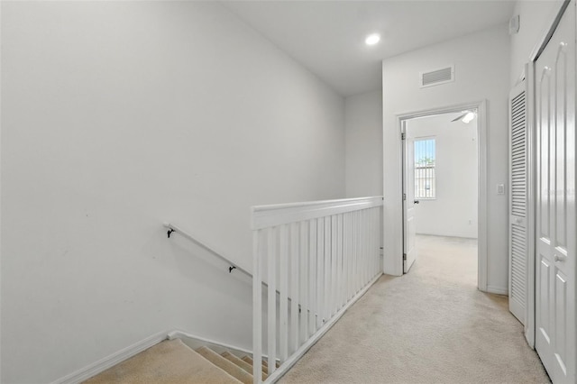 hall with visible vents, light carpet, baseboards, recessed lighting, and an upstairs landing