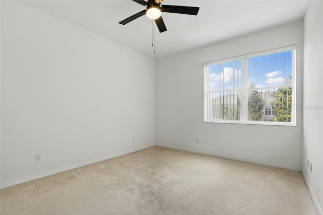 unfurnished room featuring carpet floors, baseboards, and ceiling fan