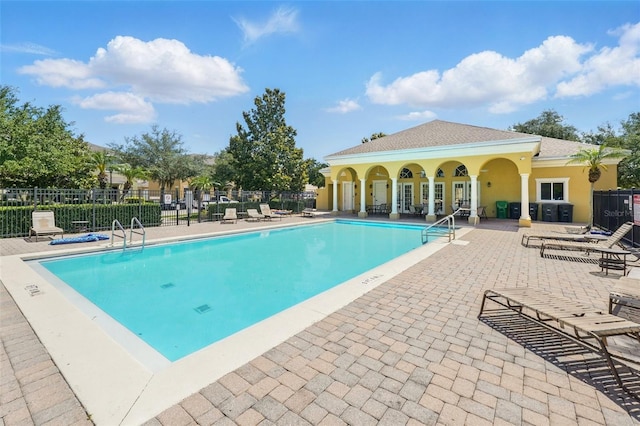 community pool featuring fence and a patio area