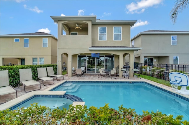 back of property with a ceiling fan, fence, a balcony, a patio, and stucco siding