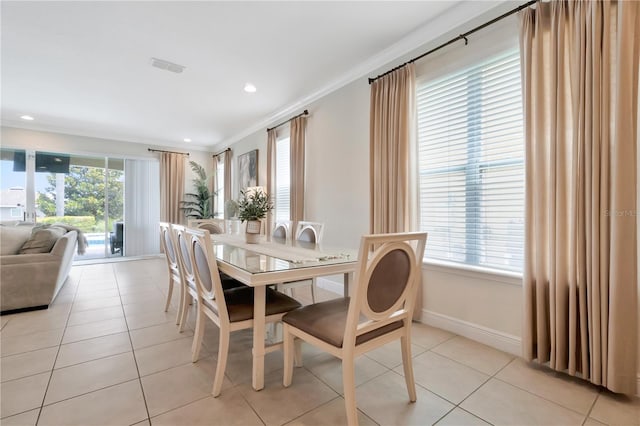 dining space with plenty of natural light, baseboards, crown molding, and light tile patterned flooring