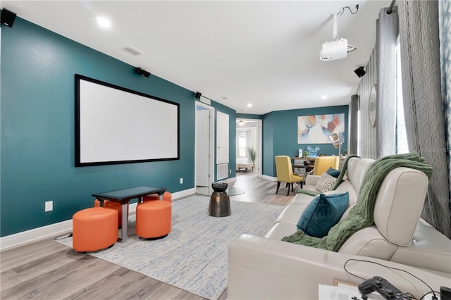 home theater with baseboards, visible vents, and wood finished floors