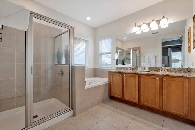 bathroom featuring tile patterned flooring, double vanity, visible vents, a garden tub, and a stall shower