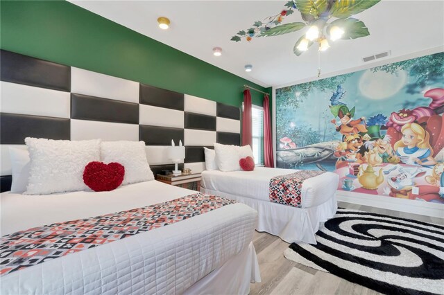bedroom with visible vents, light wood finished floors, and ceiling fan