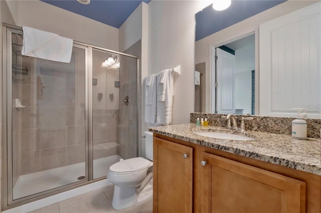 full bath featuring vanity, tile patterned floors, toilet, and a shower stall
