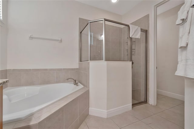 full bath with tile patterned floors, baseboards, a bath, and a stall shower