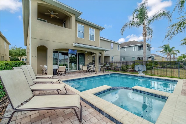 view of pool featuring ceiling fan, outdoor dining area, a pool with connected hot tub, fence, and a patio