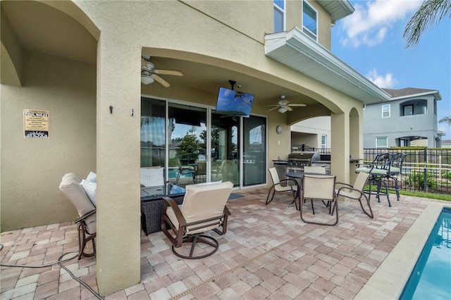 view of patio featuring fence, outdoor dining space, ceiling fan, and a grill
