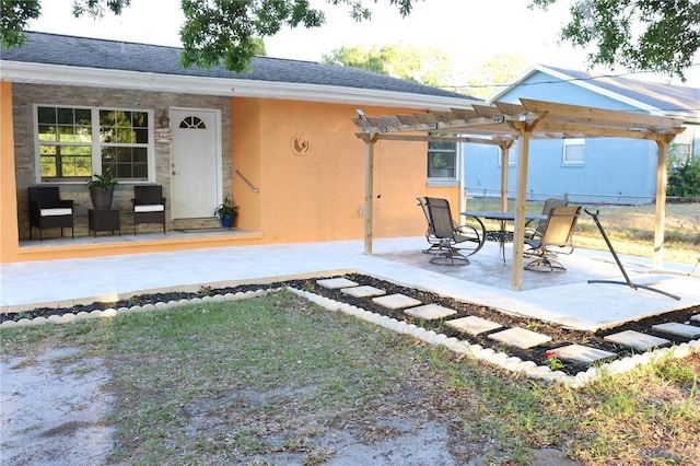 back of property featuring roof with shingles, a patio area, fence, a pergola, and stucco siding