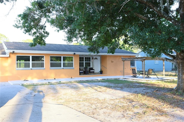back of property featuring a pergola, a patio area, and stucco siding