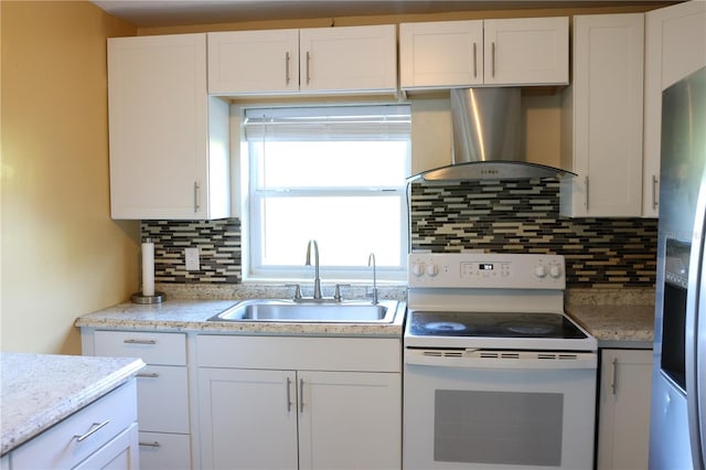 kitchen with wall chimney range hood, white cabinets, stainless steel fridge, a sink, and white range with electric cooktop