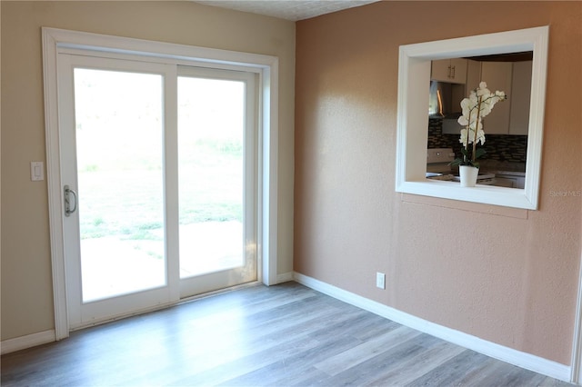 doorway to outside featuring a healthy amount of sunlight and wood finished floors