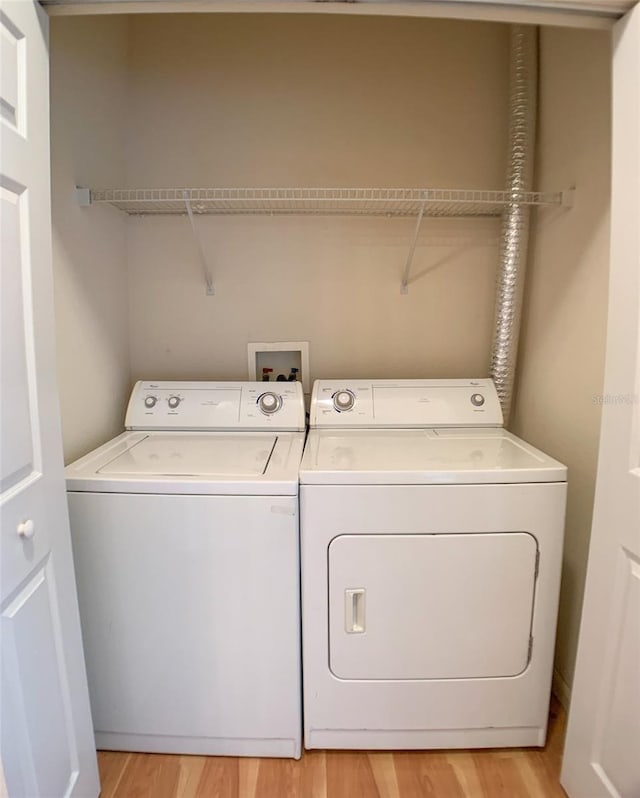 laundry area with laundry area, light wood-style flooring, and washer and dryer