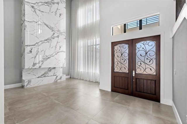 foyer with a high ceiling and baseboards