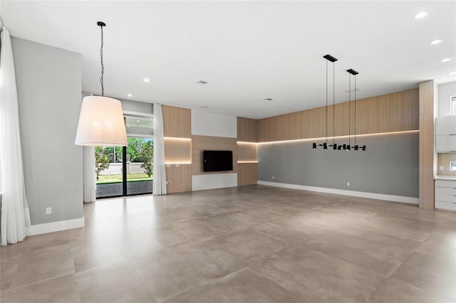 unfurnished living room featuring baseboards and recessed lighting