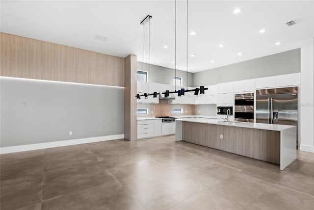 kitchen with stainless steel appliances, visible vents, modern cabinets, light countertops, and decorative backsplash