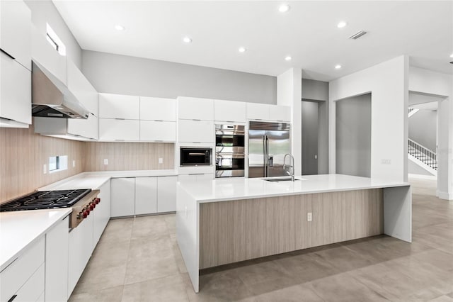 kitchen with built in appliances, a spacious island, modern cabinets, and under cabinet range hood