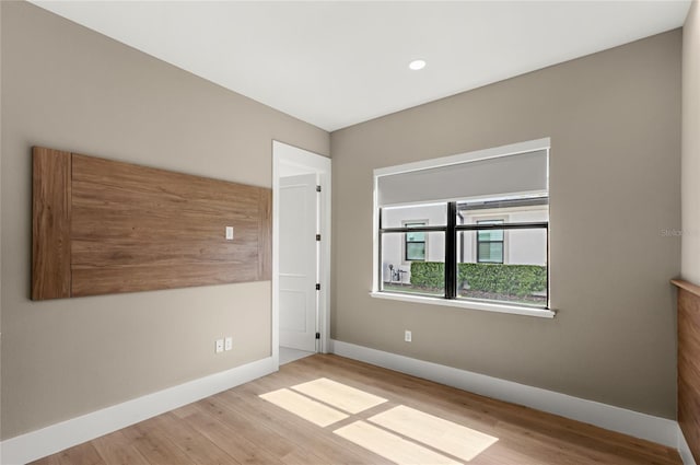 empty room featuring wood finished floors and baseboards