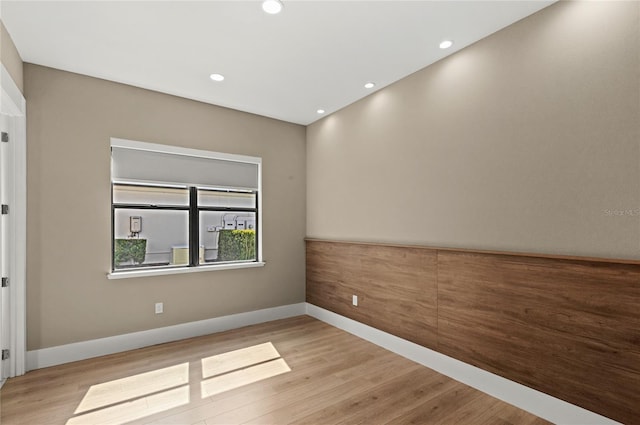 empty room with recessed lighting, baseboards, and wood finished floors