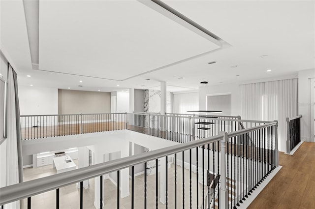 hall featuring wood finished floors, an upstairs landing, and recessed lighting