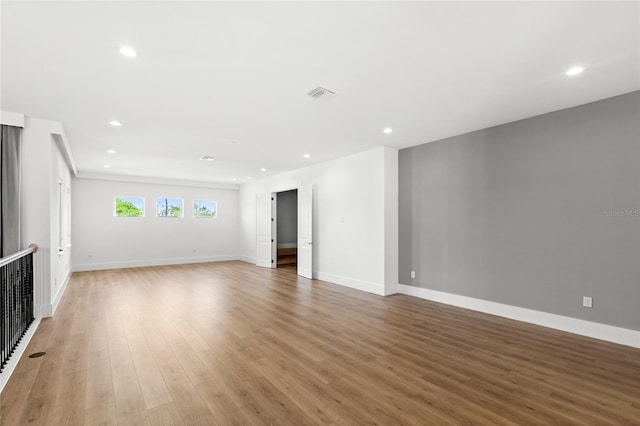 unfurnished living room featuring baseboards, light wood-type flooring, visible vents, and recessed lighting