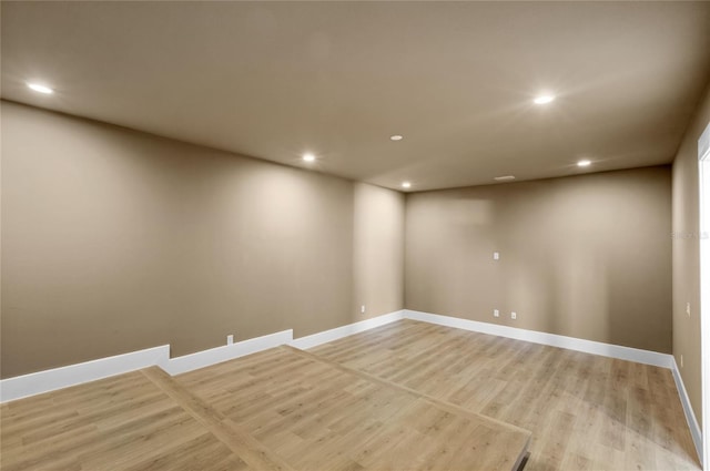 empty room with light wood finished floors, baseboards, and recessed lighting