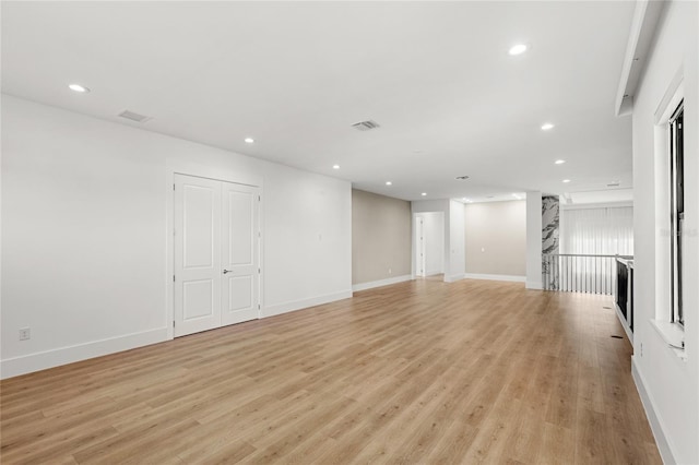 unfurnished living room featuring visible vents, light wood-style flooring, baseboards, and recessed lighting