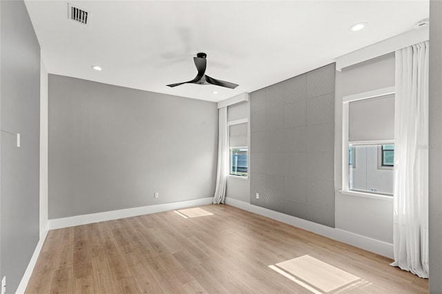unfurnished room with light wood-type flooring, baseboards, and a ceiling fan