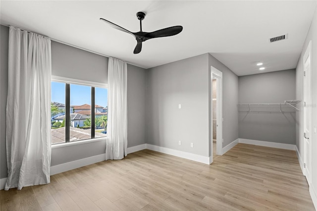 unfurnished bedroom with light wood-type flooring, visible vents, baseboards, and a ceiling fan
