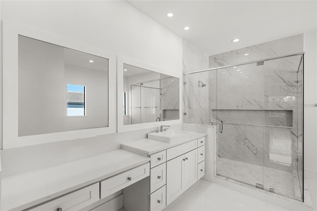 bathroom featuring a marble finish shower, vanity, and recessed lighting