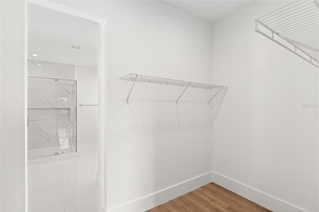 walk in closet with wood finished floors