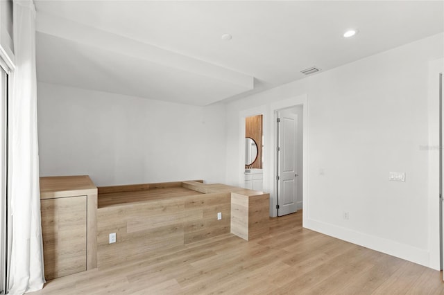 spare room with light wood-style floors, visible vents, baseboards, and recessed lighting