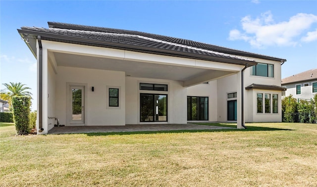 rear view of house featuring a yard, a patio area, stucco siding, and a tile roof