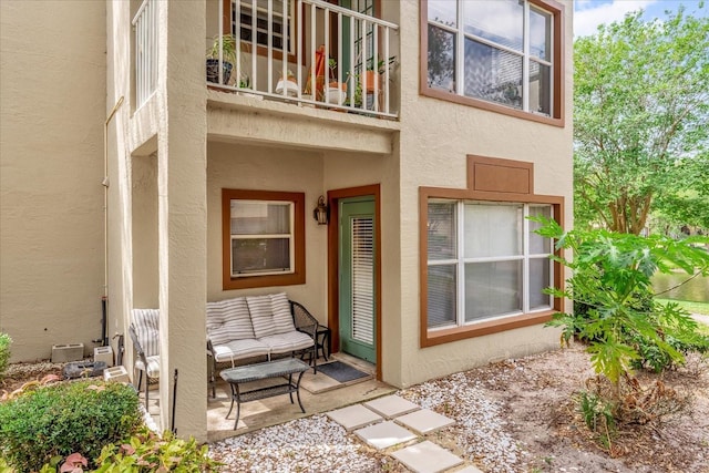 back of house featuring an outdoor hangout area, stucco siding, a patio area, and a balcony
