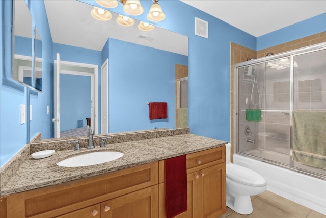 full bathroom with visible vents, vanity, toilet, shower / bath combination with glass door, and tile patterned floors