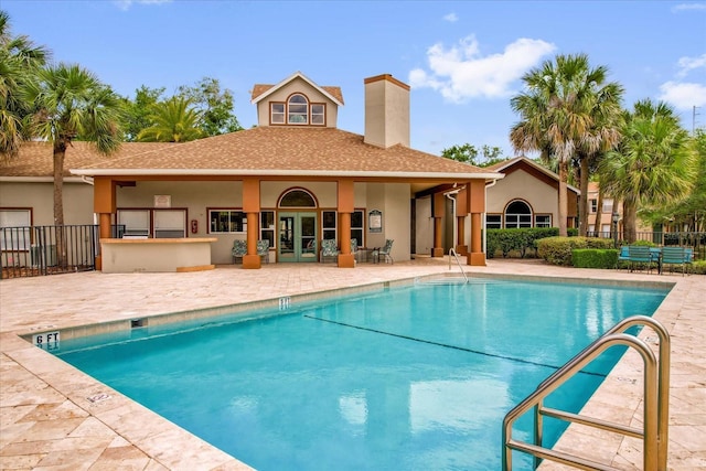 pool featuring fence, french doors, and a patio area