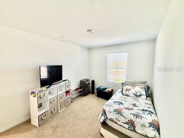 carpeted bedroom featuring a textured ceiling