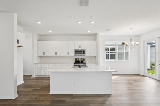 2467 Zuni Rd, Saint Cloud, FL 34771 - kitchen featuring appliances with stainless steel finishes, a sink, dark wood finished floors, tasteful backsplash, and a chandelier