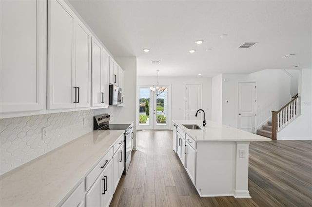 2467 Zuni Rd, Saint Cloud, FL 34771 - kitchen with appliances with stainless steel finishes, a sink, dark wood-style floors, a chandelier, and decorative backsplash