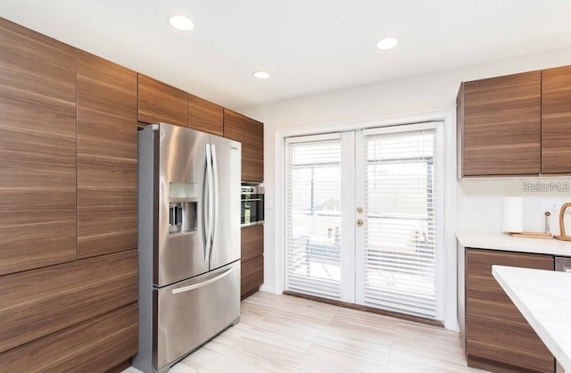 631 Trailwood Dr, Altamonte Springs, FL 32714 - kitchen with brown cabinetry, modern cabinets, stainless steel fridge, light countertops, and recessed lighting
