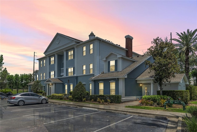 7630 Heritage Crossing Way Unit 302, Reunion, FL 34747 - view of front of home featuring uncovered parking, a chimney, and stucco siding