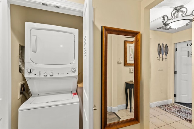 7630 Heritage Crossing Way Unit 302, Reunion, FL 34747 - washroom with stacked washer and clothes dryer, light tile patterned floors, and baseboards