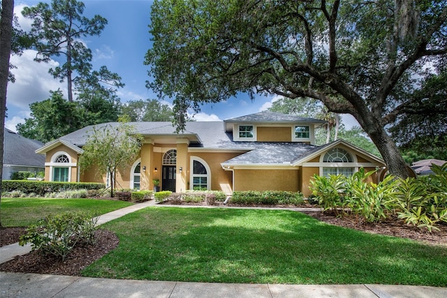 view of front of house featuring stucco siding and a front lawn