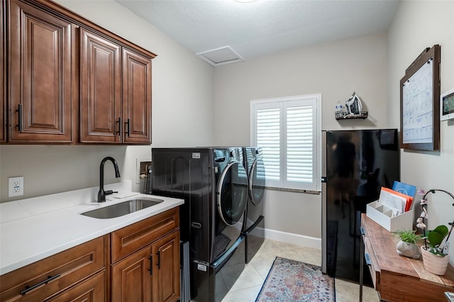 clothes washing area featuring baseboards, washer and dryer, light tile patterned flooring, a sink, and cabinet space