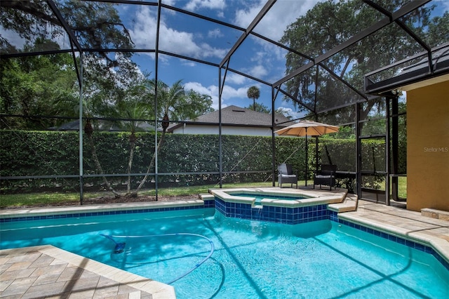 view of pool featuring a pool with connected hot tub, a patio area, and glass enclosure