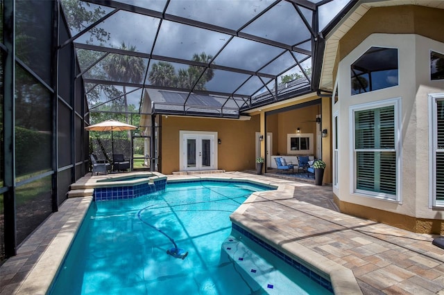 view of swimming pool with french doors, a ceiling fan, a pool with connected hot tub, a patio area, and glass enclosure