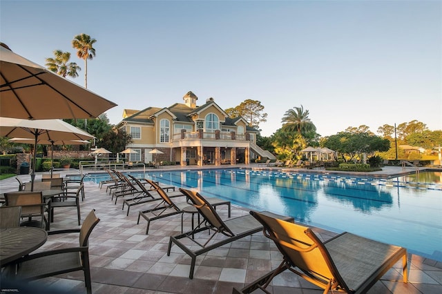 community pool with a patio and stairs